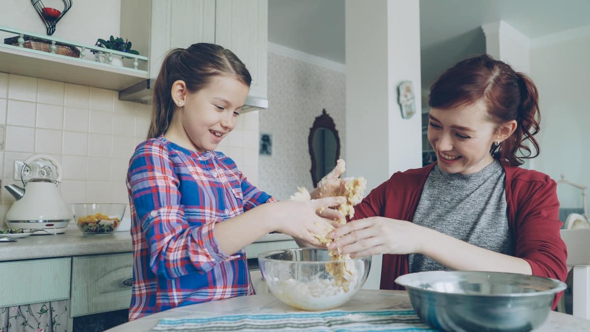 Mor och dotter knådar deg och skrattar