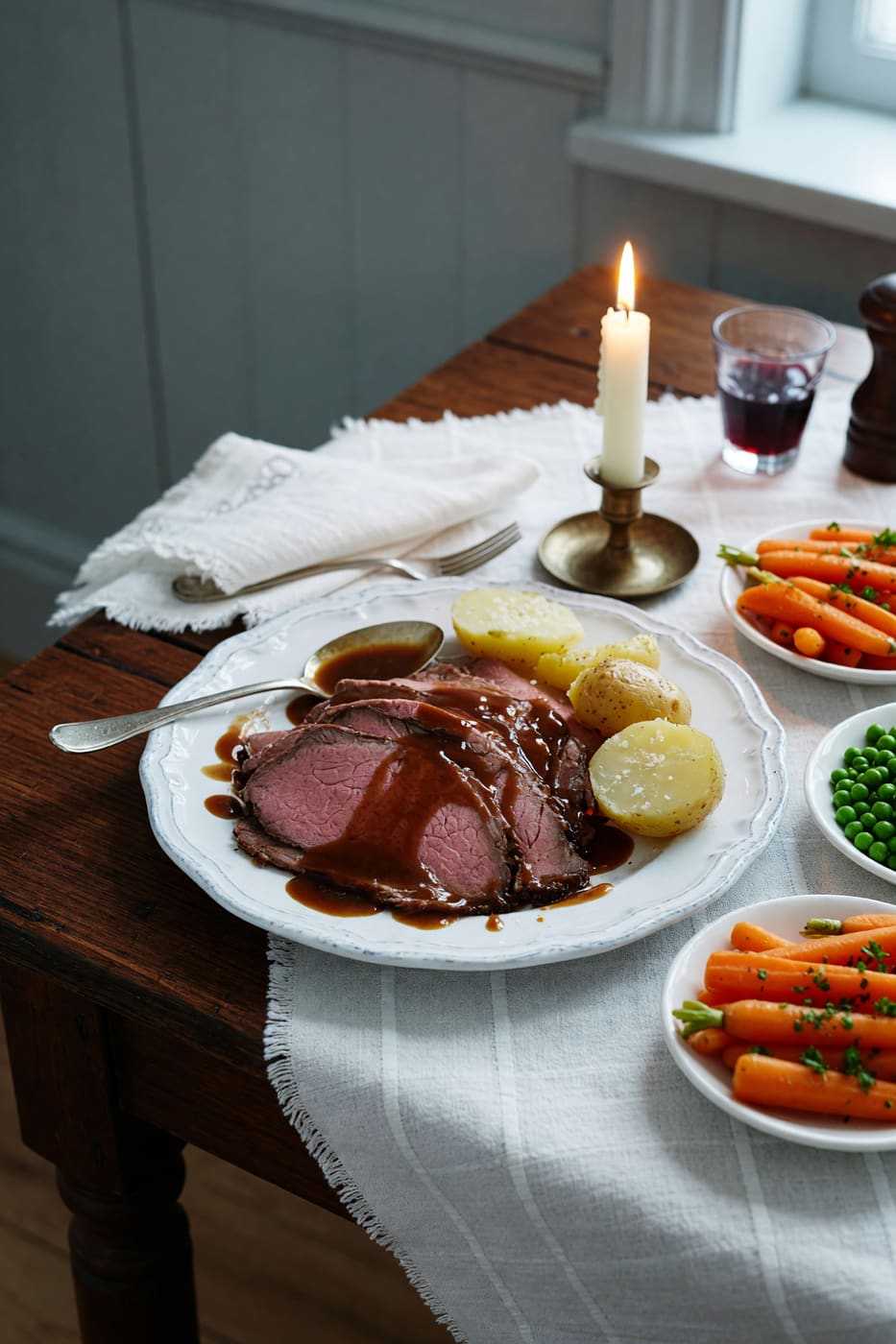 Söndagsstek med potatis på ett dukat bord